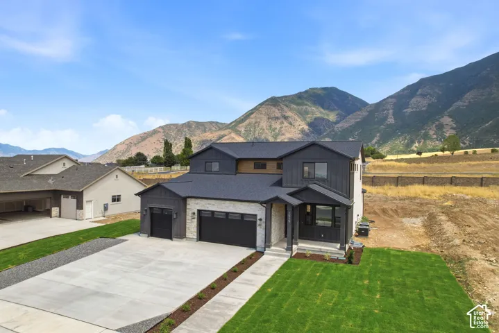 Contemporary two-story residence featuring a dark gray siding and light-toned stone exterior