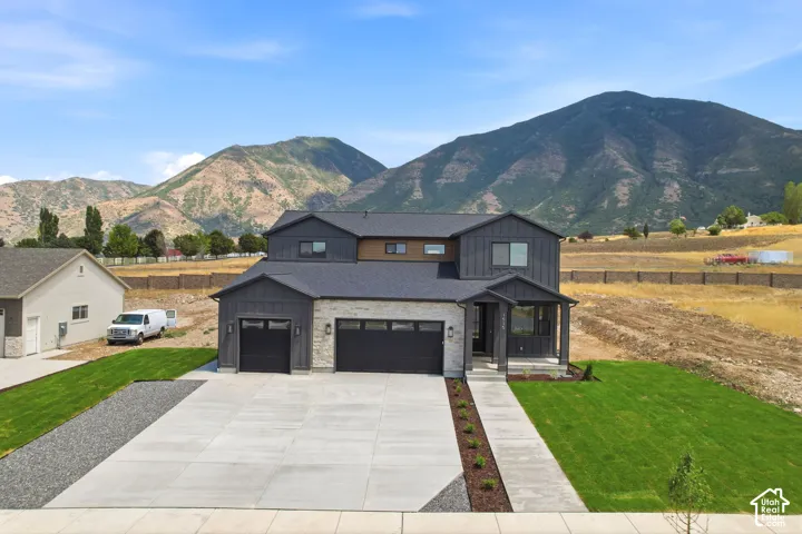 Modern two-story residence with a stone and dark siding facade
