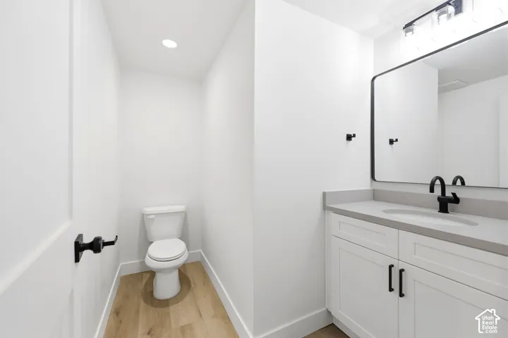 Contemporary bathroom featuring a single vanity with white cabinetry, a light-toned countertop, and a black-framed mirror