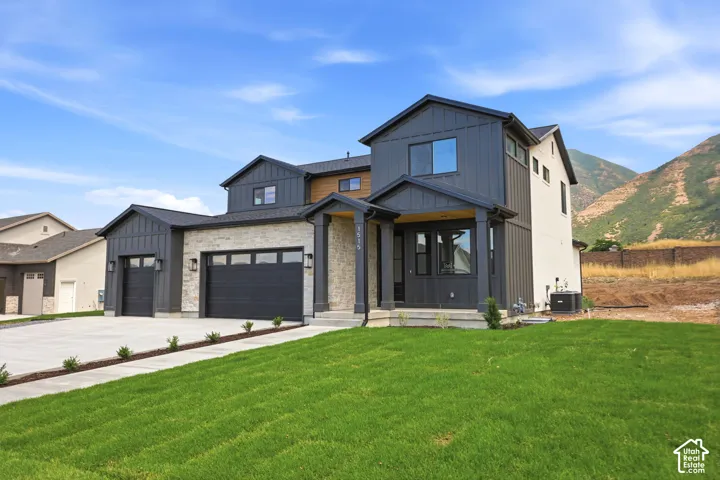 Contemporary exterior featuring board and batten siding, stone accents, a covered entry porch, and a three-car garage