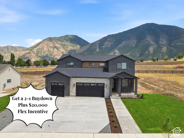Modern two-story residence featuring a dark gray siding and stone facade, a two-car garage, and a covered entry porch