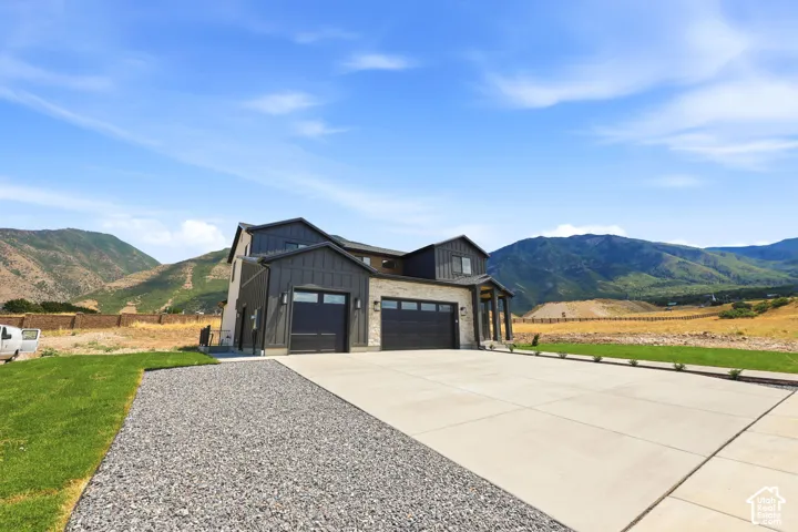 Contemporary two-story residence featuring a dark gray vertical siding and light-colored stone facade