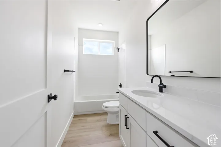 Modern bathroom featuring a single vanity with a white countertop and undermount sink, matte black faucet, and a large framed mirror