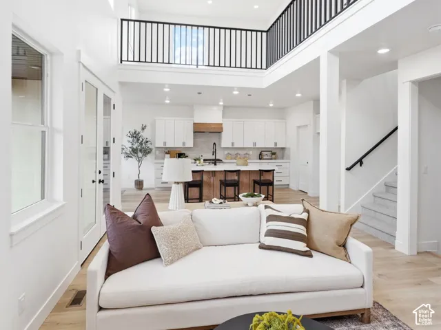 Bright open-concept living area with a double-height ceiling and transom windows