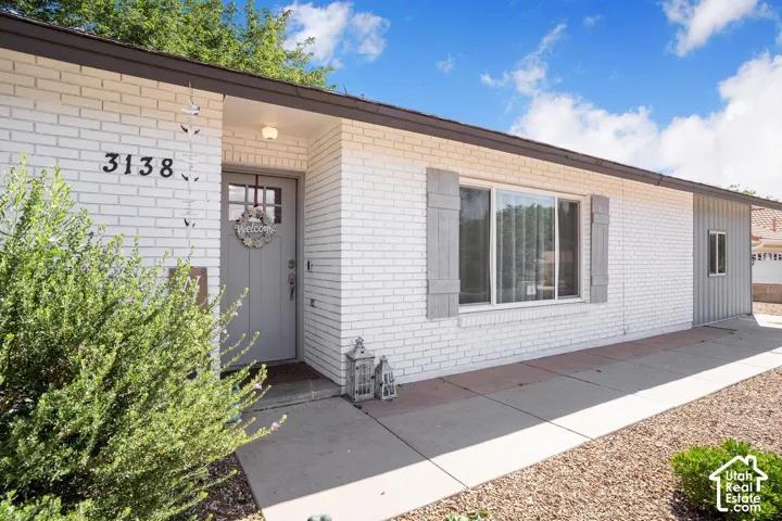 White brick exterior with gray shutters and a gray front door