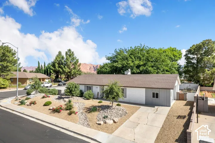 Single-story residence with a brown shingle roof, white and gray exterior, and a concrete driveway