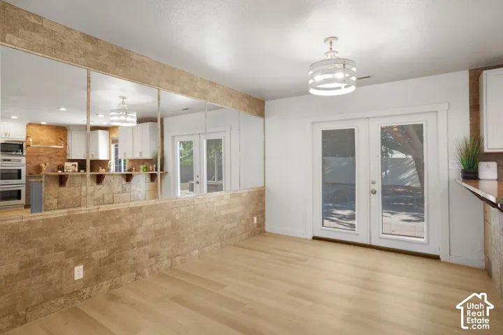 Light wood-finish flooring with a modern ceiling light fixture