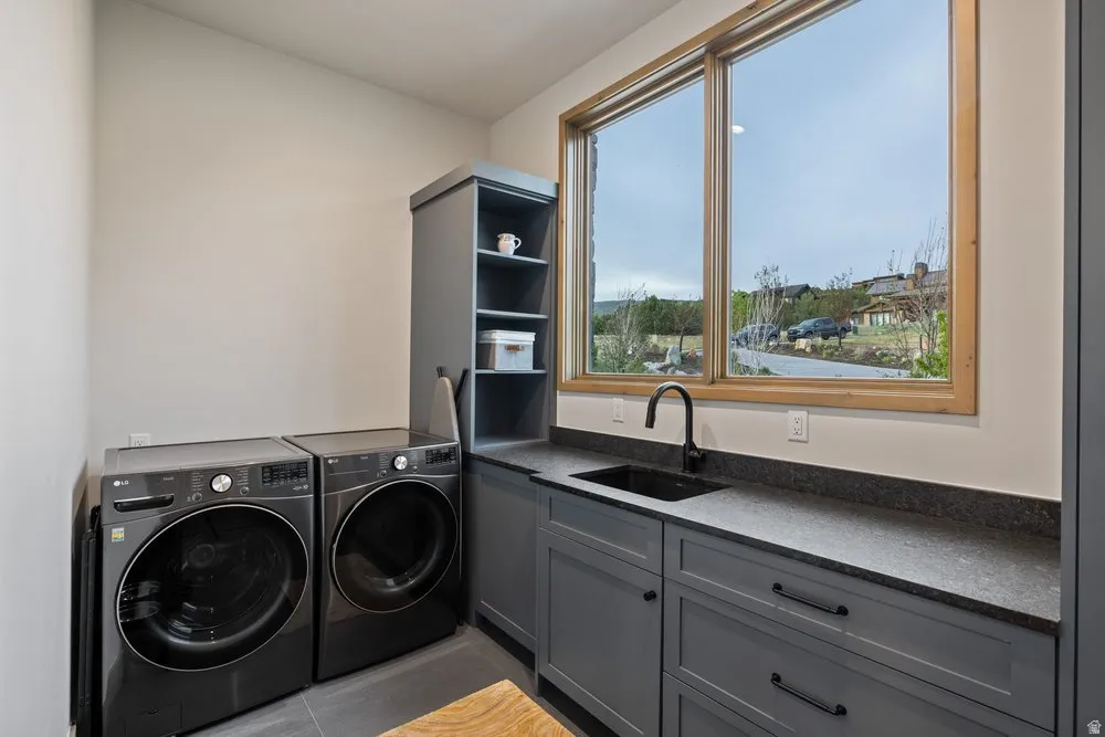 Utility room featuring a dark gray countertop, black undermount sink, and black gooseneck faucet