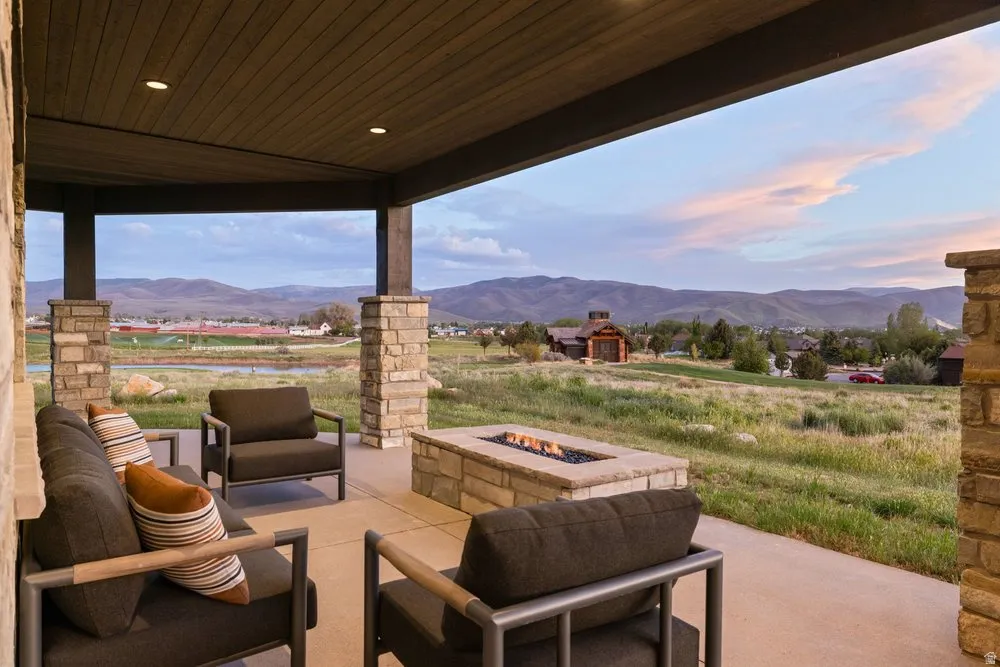 Covered outdoor patio featuring stone columns and a concrete floor