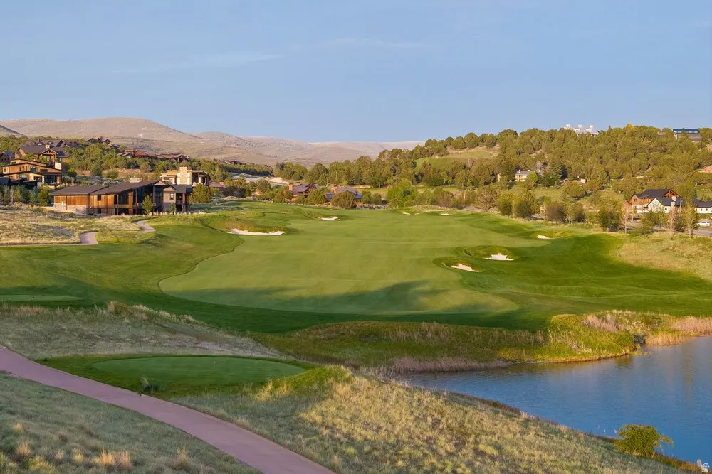 Expansive golf course featuring manicured greens, sand traps, and a pristine water hazard
