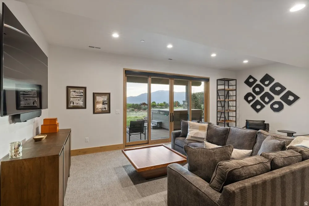 Recessed lighting illuminating a spacious room with carpeted flooring and white walls