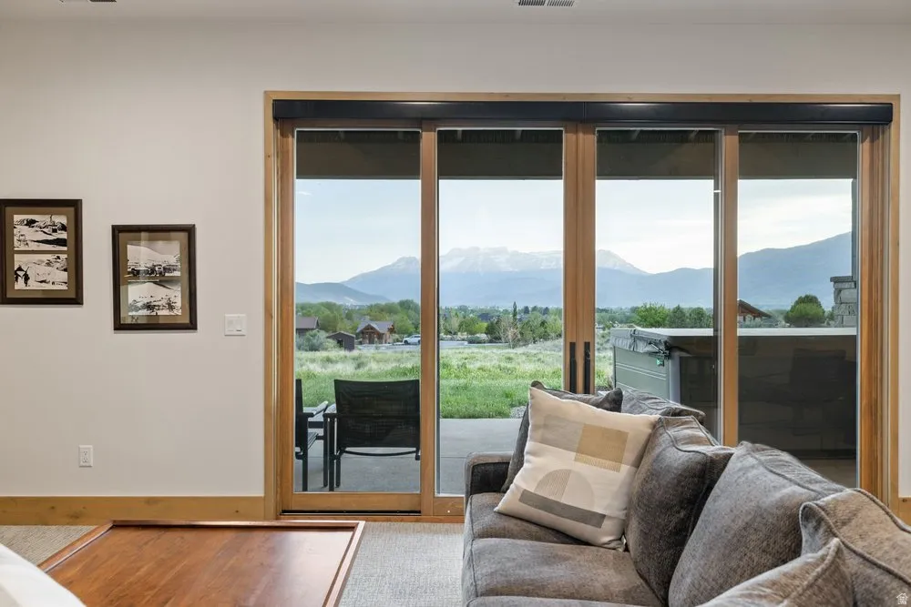 Expansive sliding glass doors with natural wood frames open to a patio