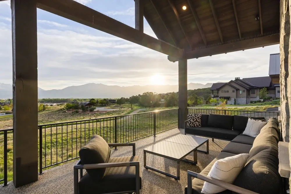Expansive covered patio featuring a textured floor surface, a natural wood-finish ceiling, and sturdy stone exterior wall