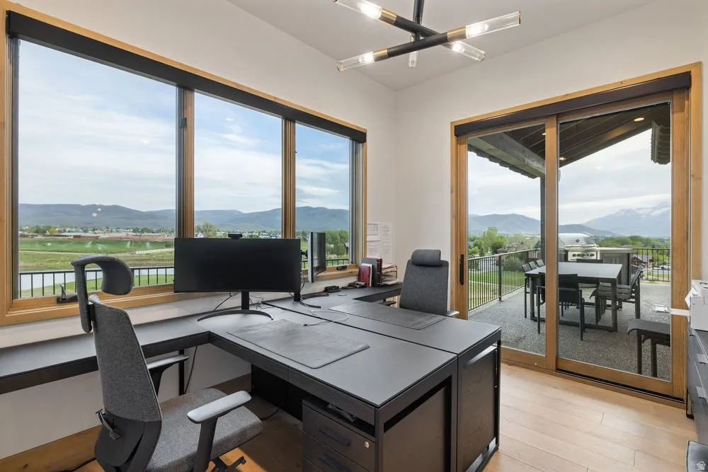 Room featuring extensive window arrays, a built-in desk, and light wood-finish flooring