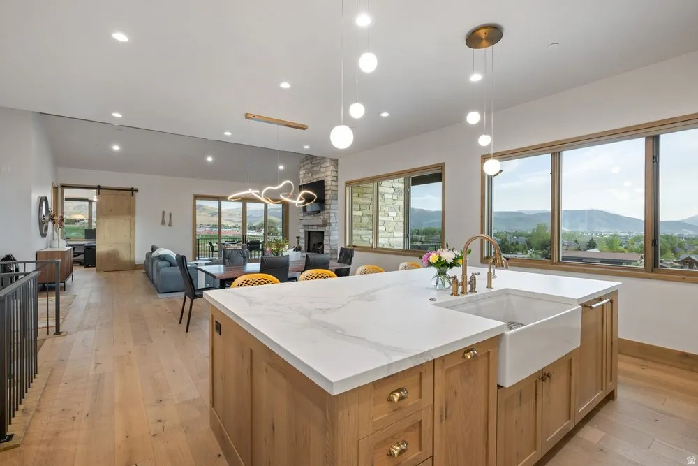 Kitchen island featuring a farmhouse sink, gold-tone fixtures, and a light-toned countertop