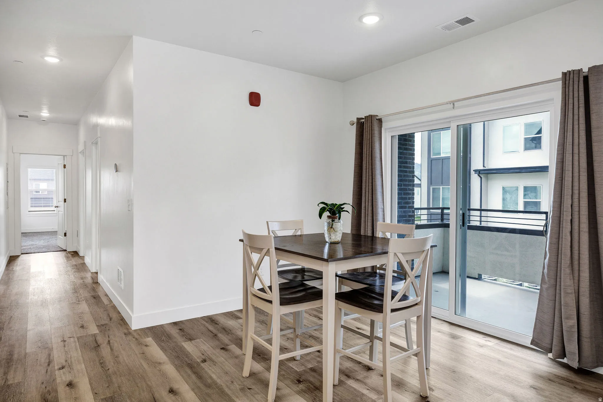 Dining area featuring wood-finish flooring, recessed lighting, and a sliding glass door opening to a private balcony