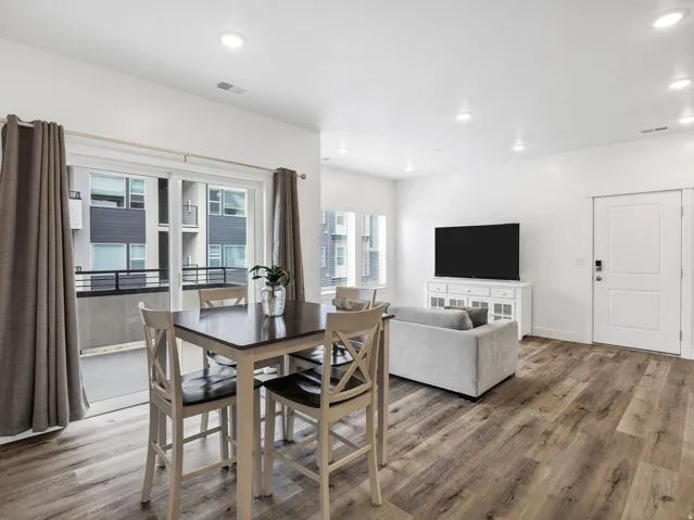 Open concept living area featuring wood-finish flooring, recessed lighting, and a white interior door
