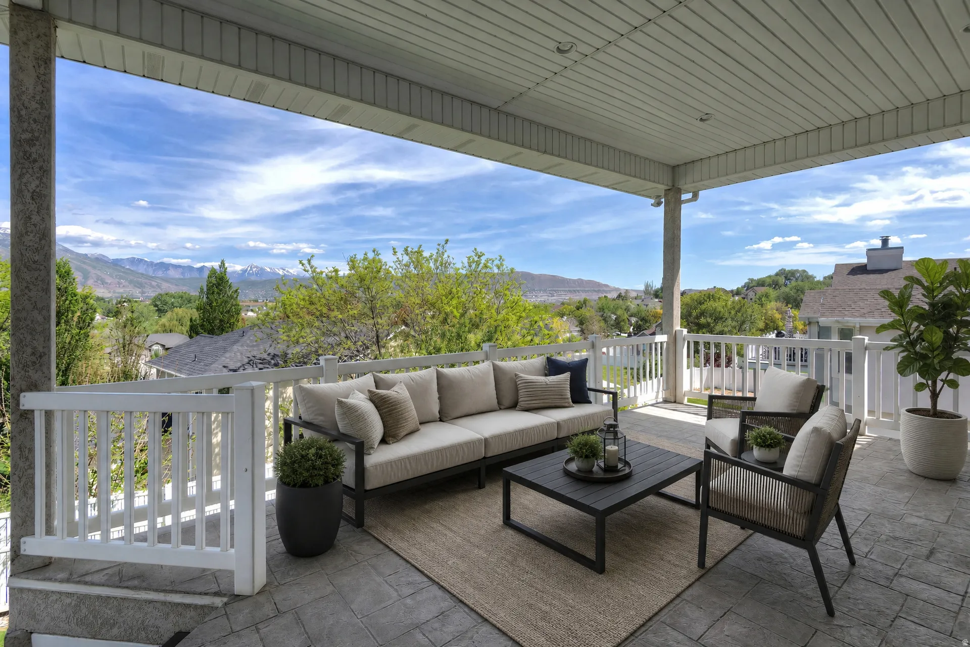 Covered outdoor patio featuring stamped concrete flooring and white railing