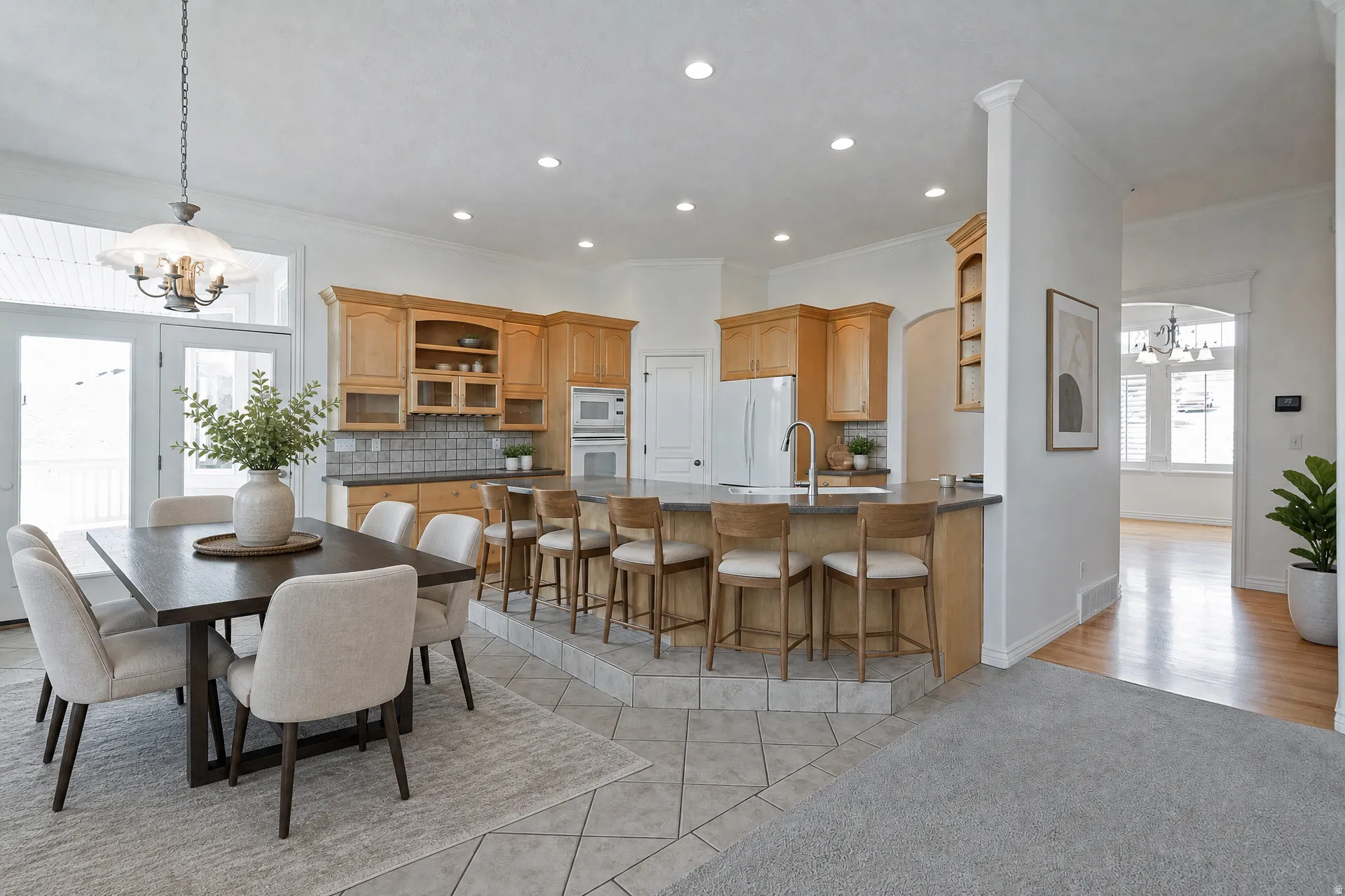 Open-concept kitchen and dining area featuring light wood cabinetry, a center island with bar seating, and stainless steel appliances