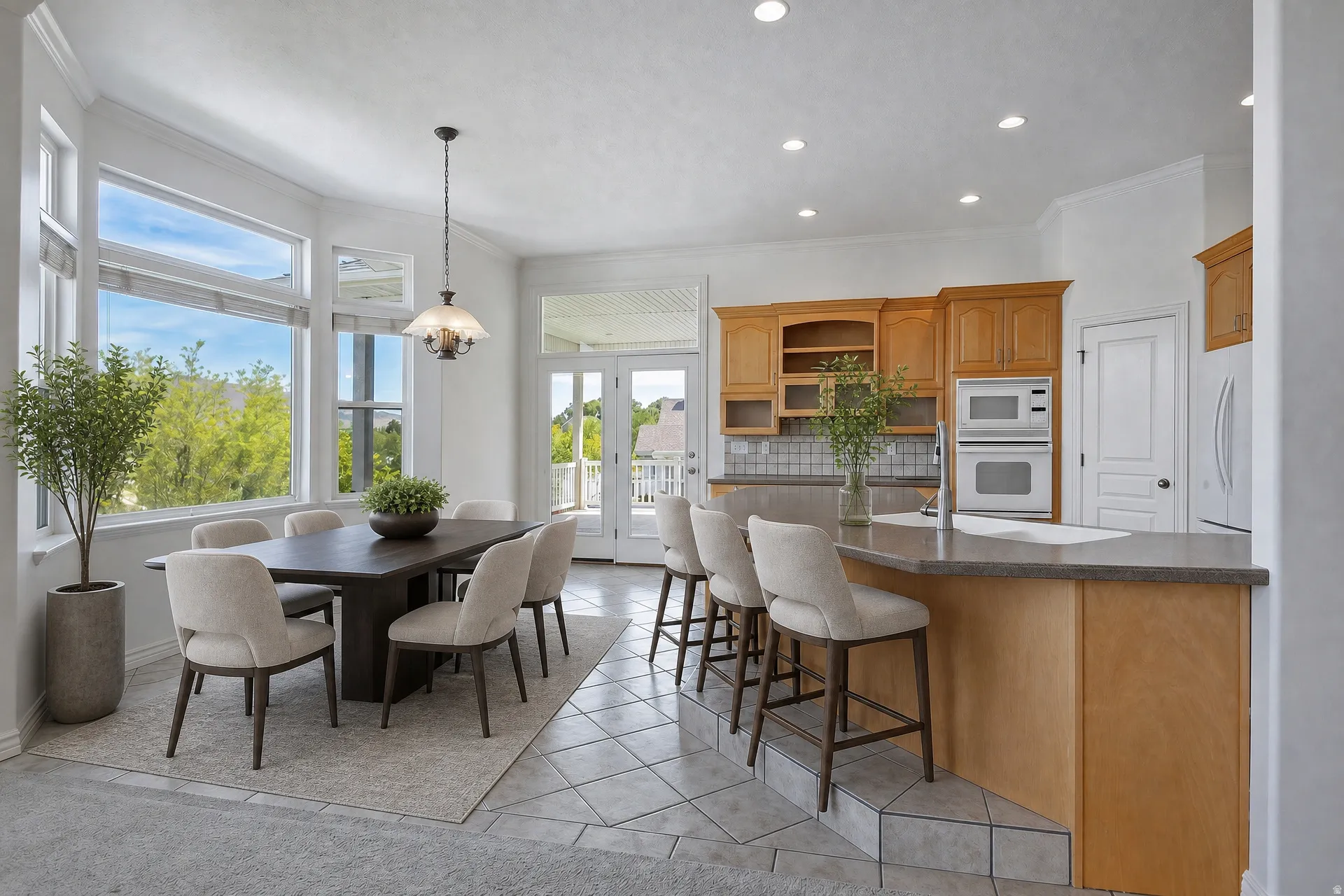 Open-concept dining area featuring a bay window, a kitchen island with seating, double French doors, recessed lighting, and tile flooring