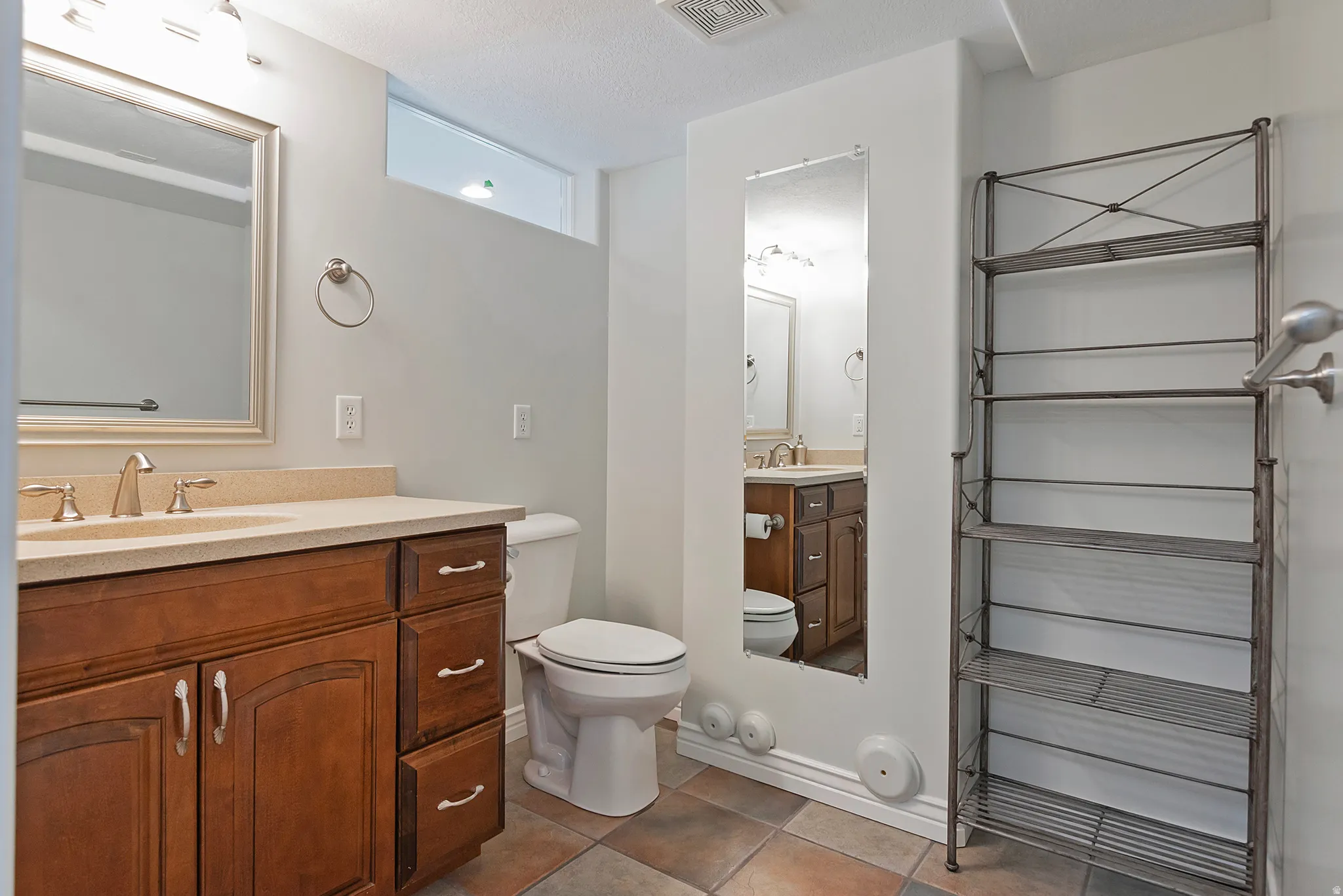 Bathroom vanity with a light-colored countertop, dual-basin sink, and brushed nickel fixtures