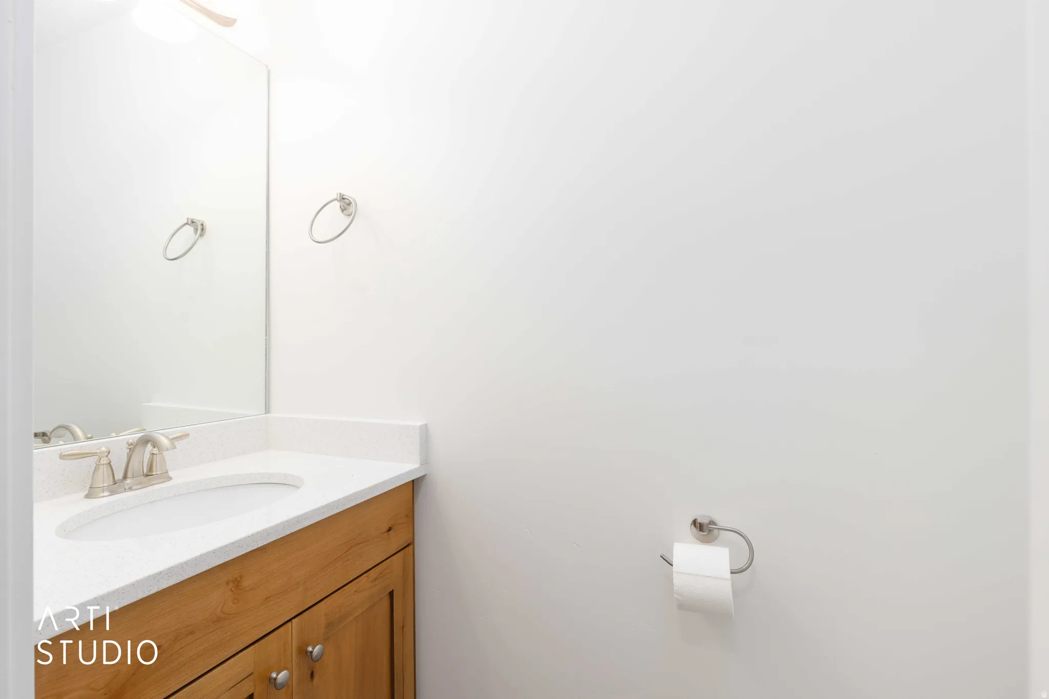 Wood-finish vanity with a white countertop and undermount sink