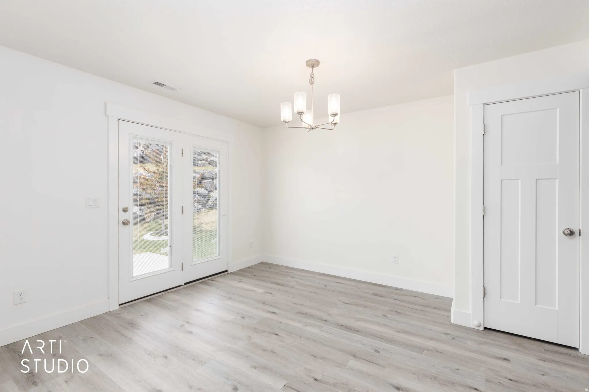Light wood-finish flooring with white baseboards and walls
