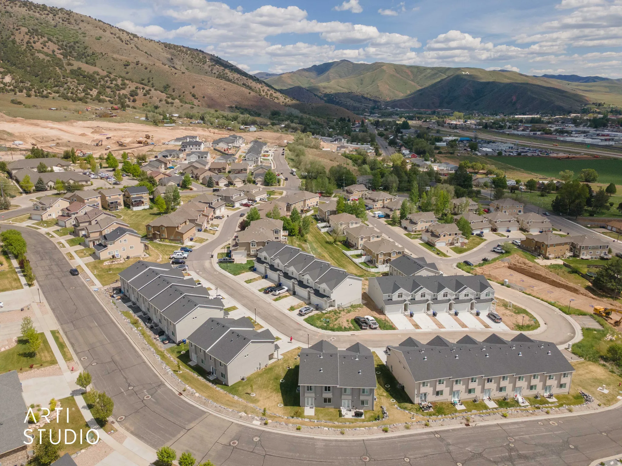 Aerial perspective showcasing a residential community with contemporary townhomes and single-family residences