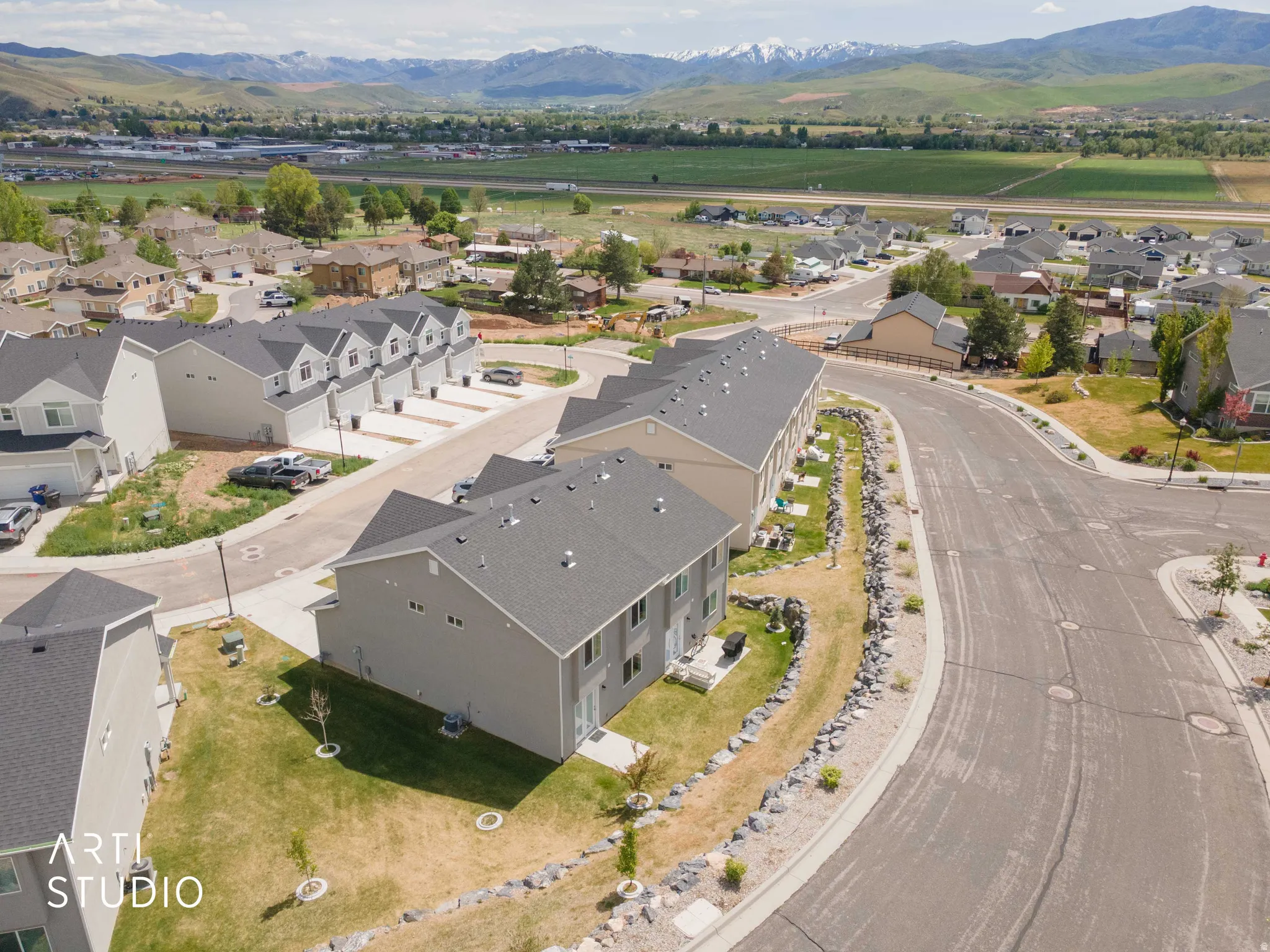 New construction townhome community featuring contemporary gray siding and dark shingle roofs