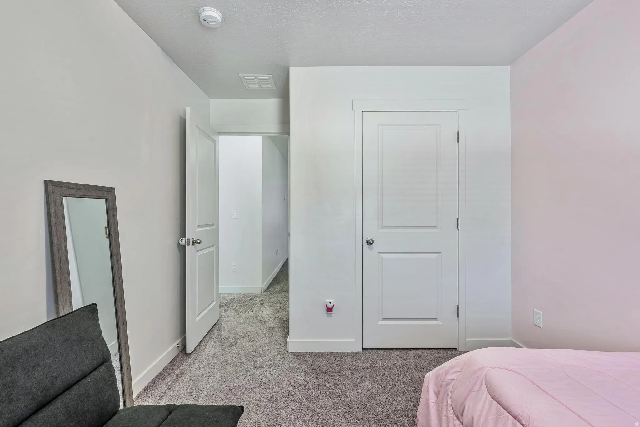 Interior room with light gray carpeting, white trim, and a white paneled door