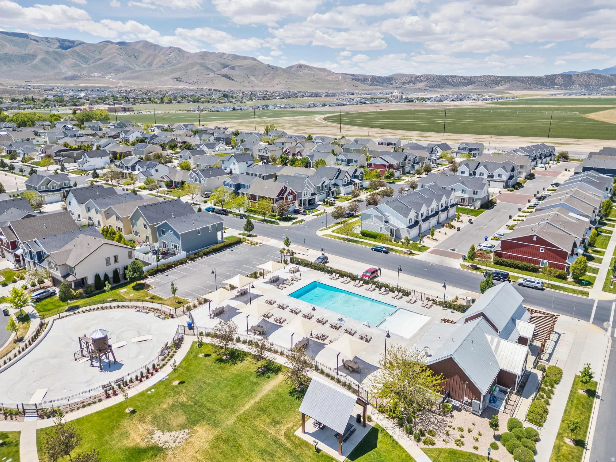 Community with an outdoor swimming pool, shaded lounge areas, and a playground