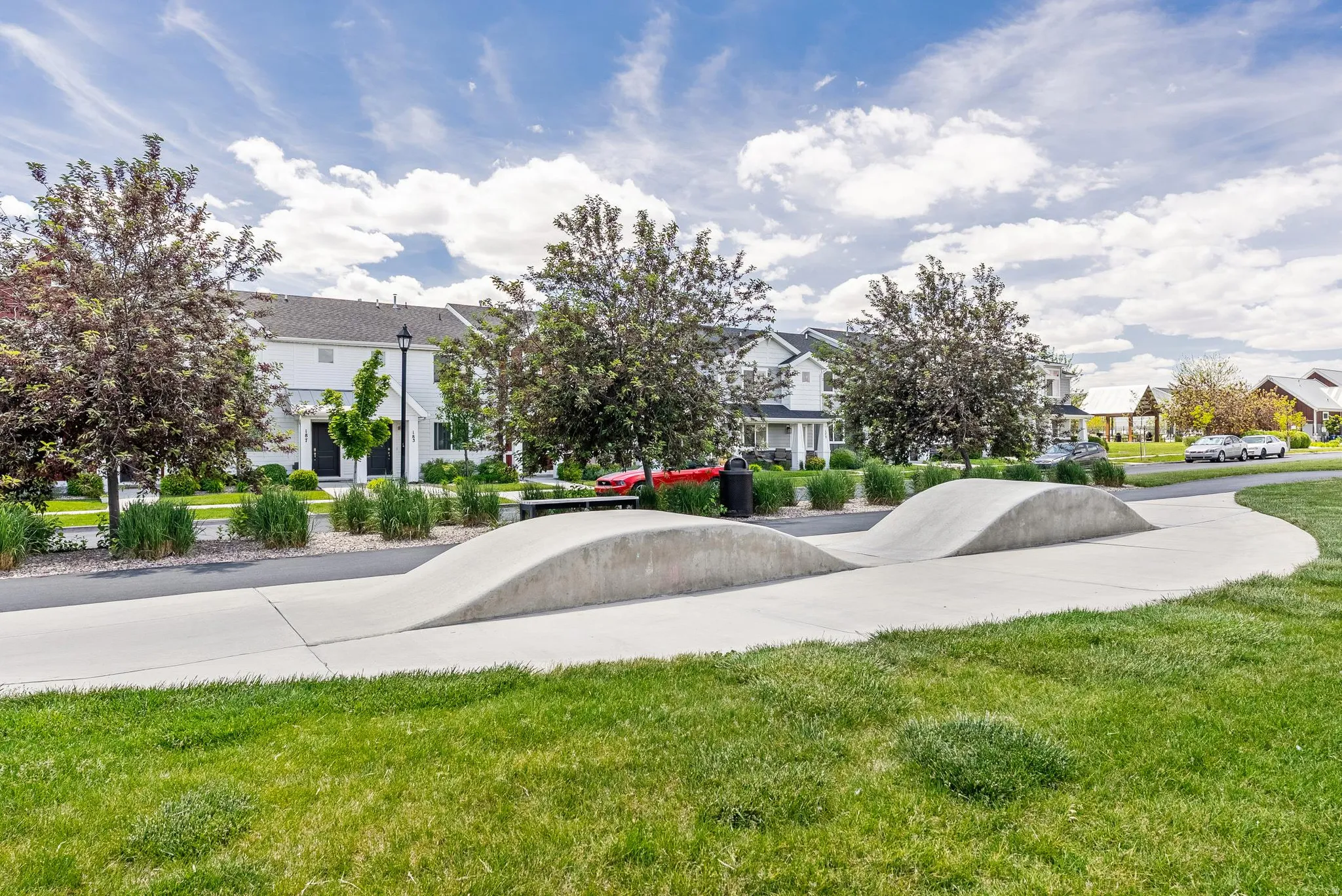 Community green space featuring a concrete pump track and manicured lawn