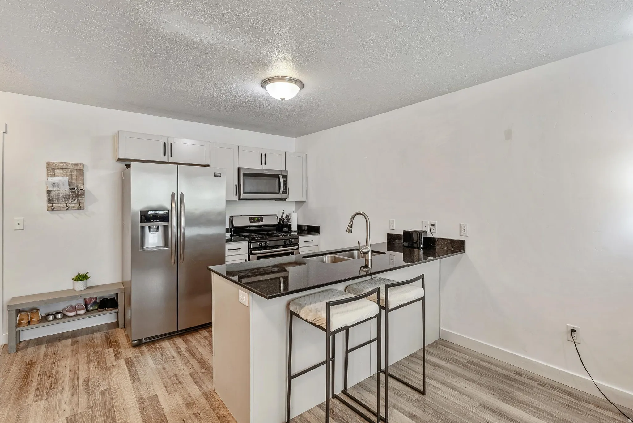 Modern kitchen featuring an island with seating, dark countertops, and stainless steel appliances