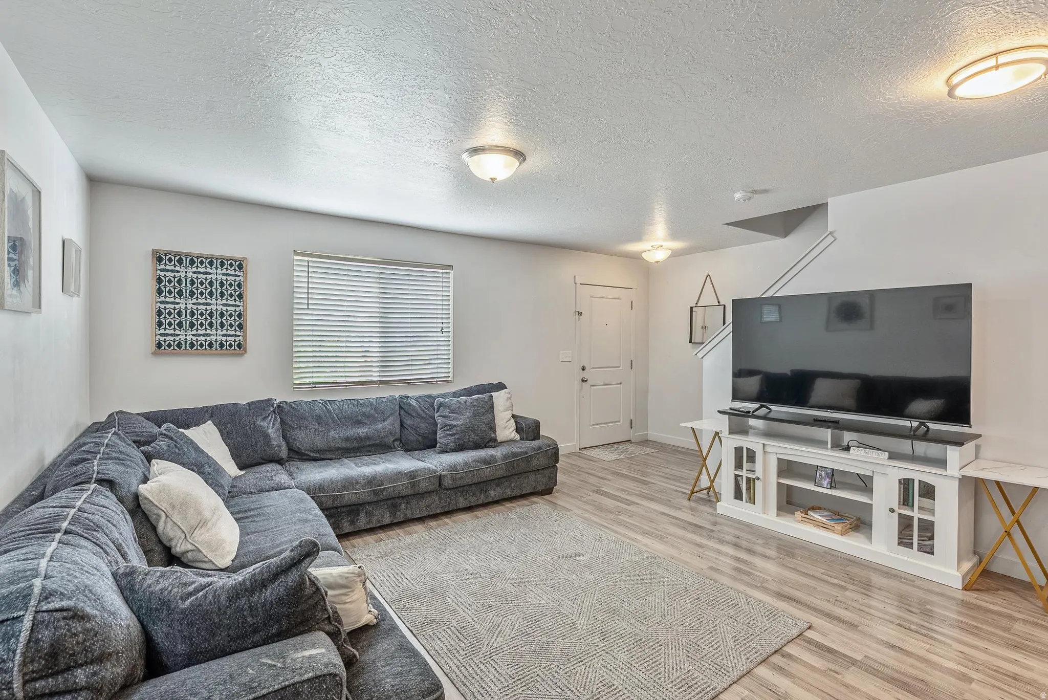 Open-concept living space featuring wood-finish flooring and a neutral color palette