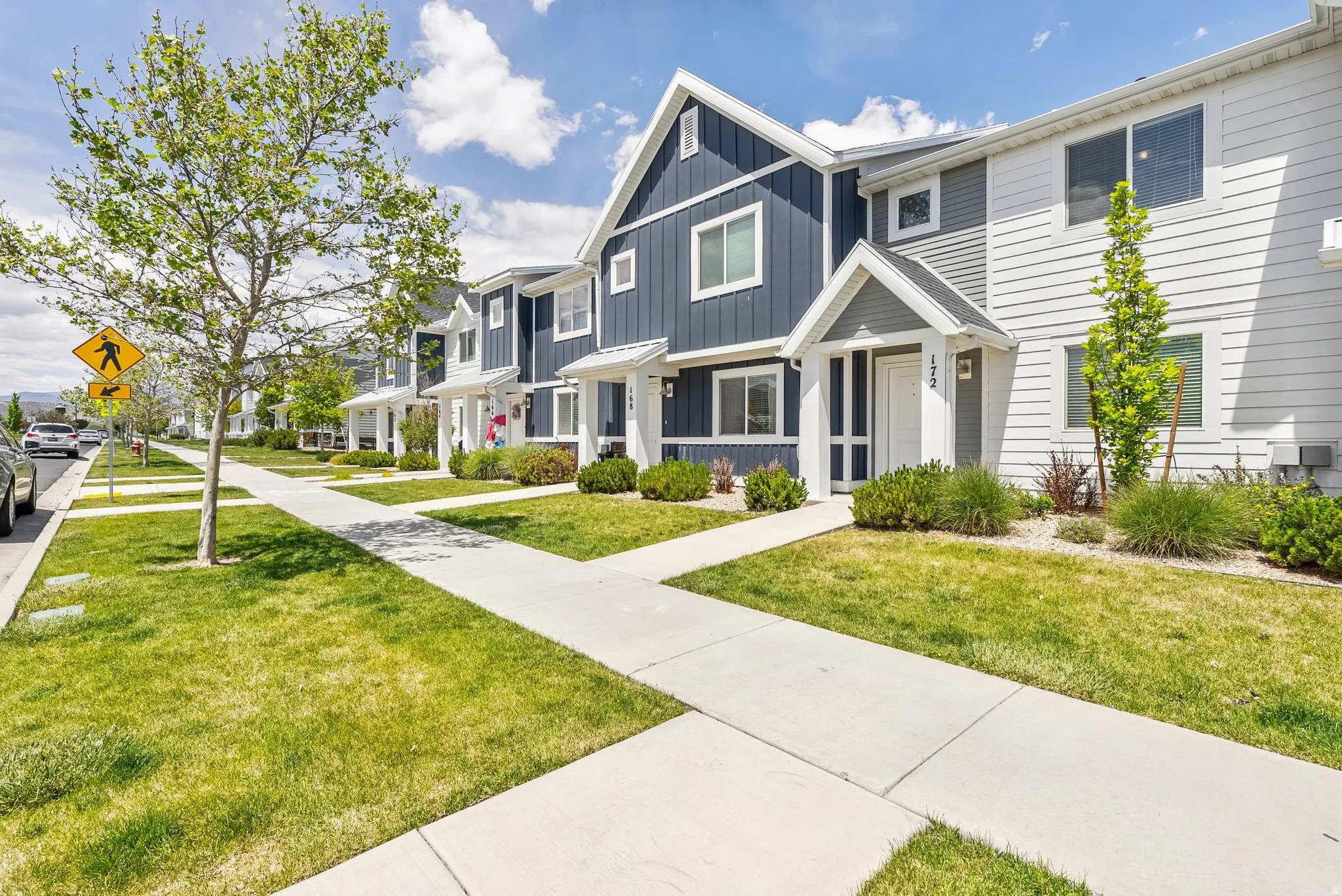 Contemporary townhome-style residences featuring a blend of dark blue board and batten siding with white horizontal siding