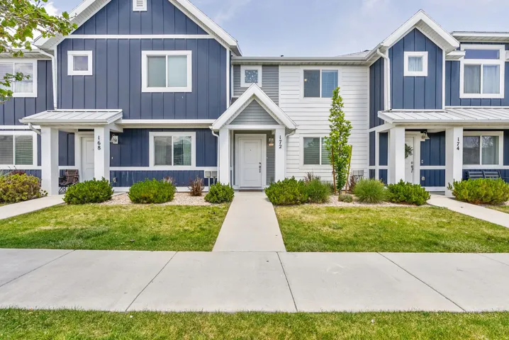Modern townhome exterior featuring blue vertical siding and white horizontal siding accents