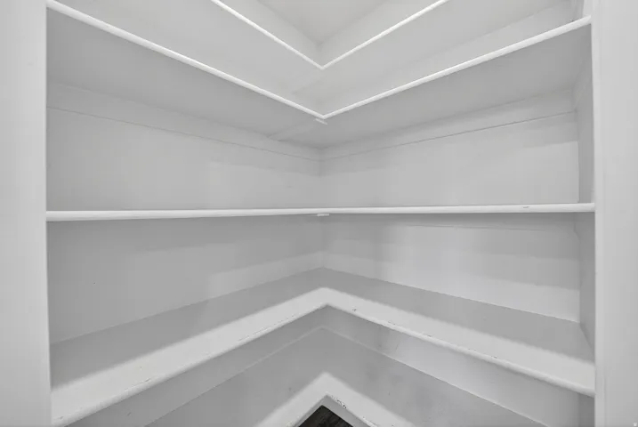 Built-in shelving unit featuring multiple levels of storage and a bright white finish