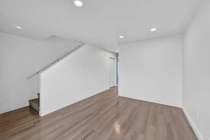 Open-concept area featuring wood-finish flooring, recessed lighting, and white walls