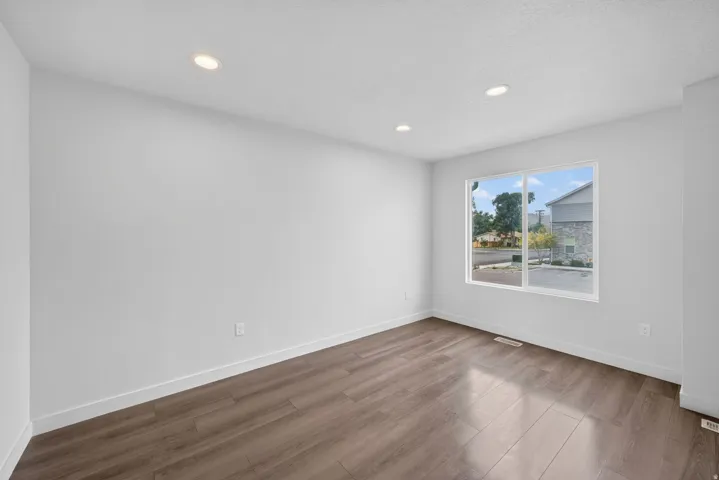 Bright room featuring wood-finish flooring, recessed lighting, and a large window