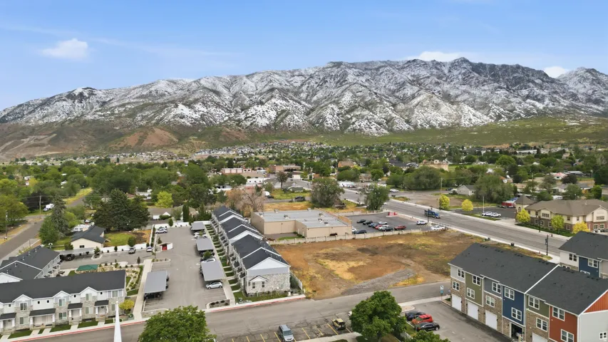 Aerial perspective showcasing a residential area with a prominent snow-capped mountain range in the background