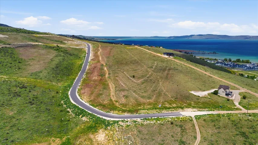 Expansive undeveloped land featuring a paved road and lush green hillsides