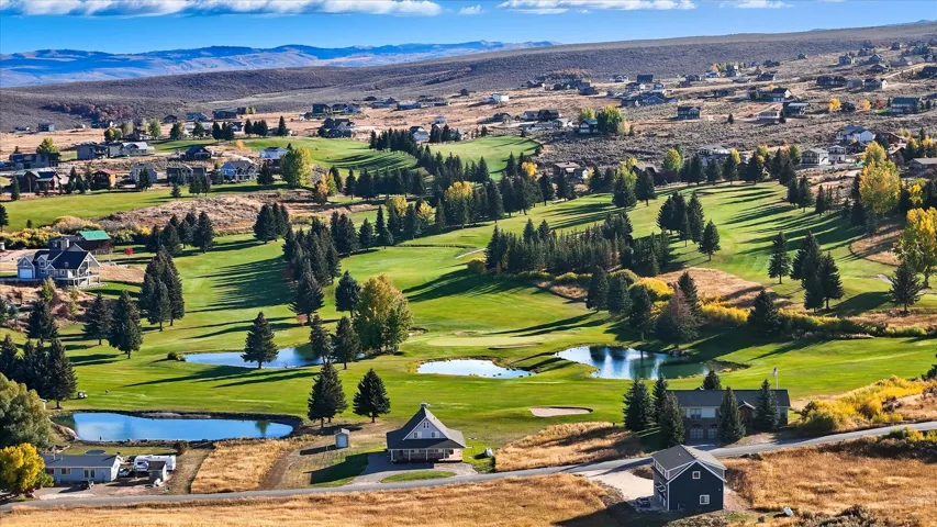 Expansive golf course terrain featuring manicured greens and multiple water features
