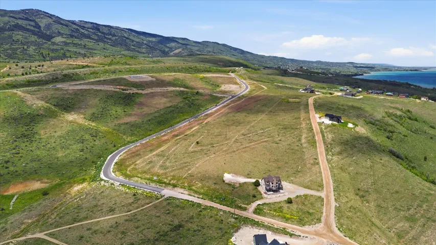 Expansive acreage with a partially paved road and a single-family residence