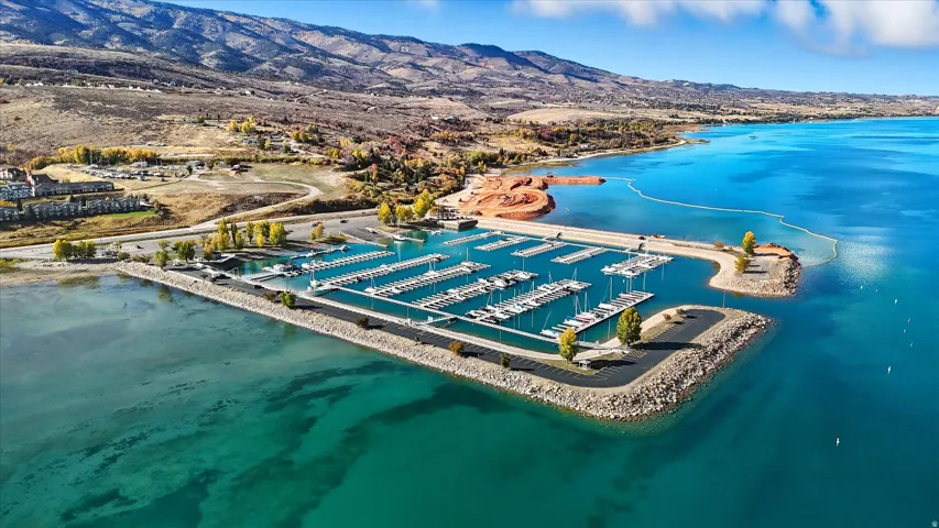 Marina featuring multiple boat slips, rock-armored breakwaters, and surrounding clear blue waters