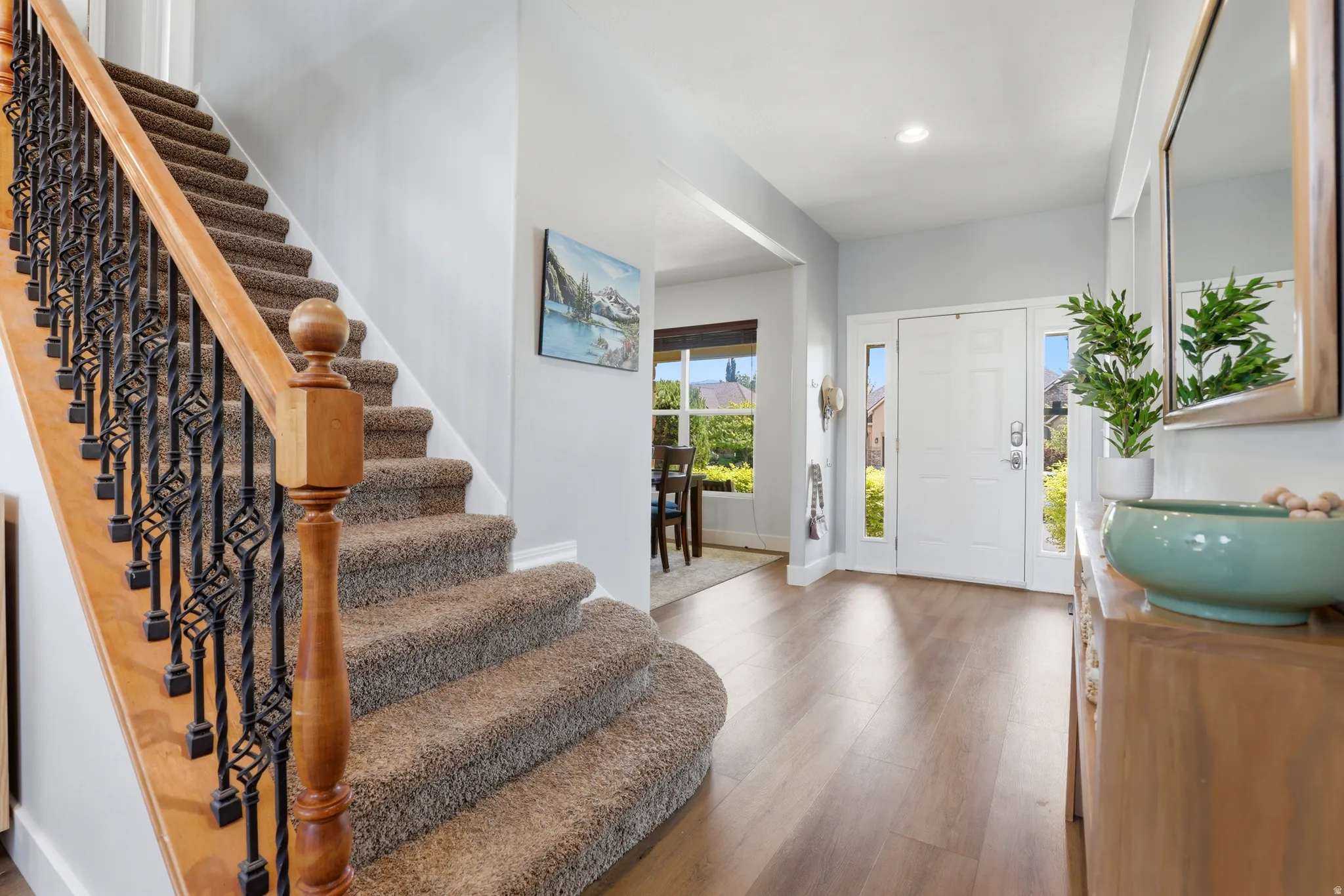 Entryway with wood-finish flooring, a white paneled front door with sidelights, and recessed lighting