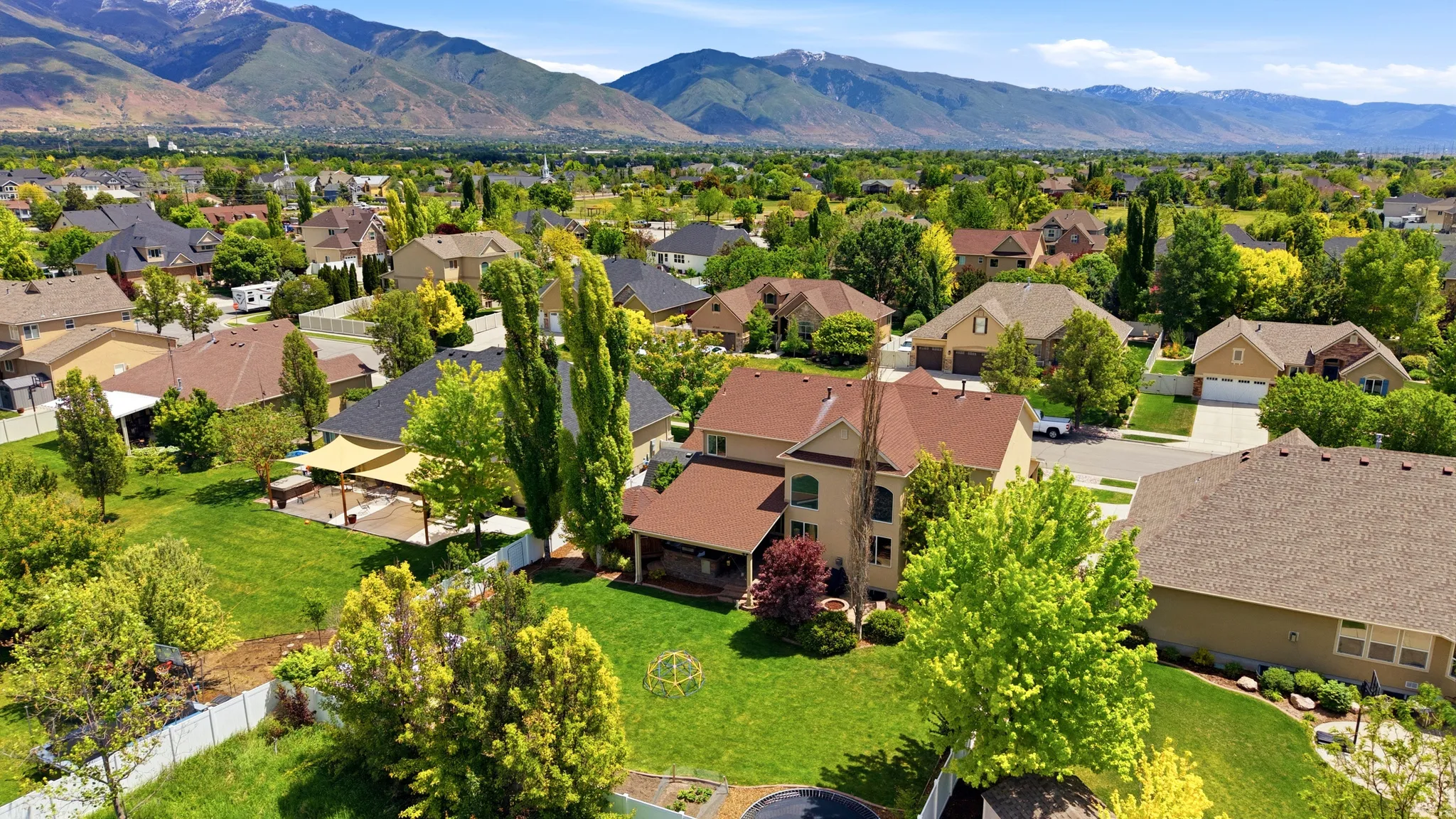 Expansive residential property featuring a stucco exterior and a tan shingle roof