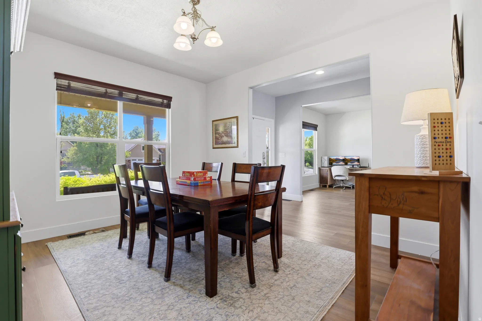 Dining area featuring a contemporary chandelier and large window with blinds