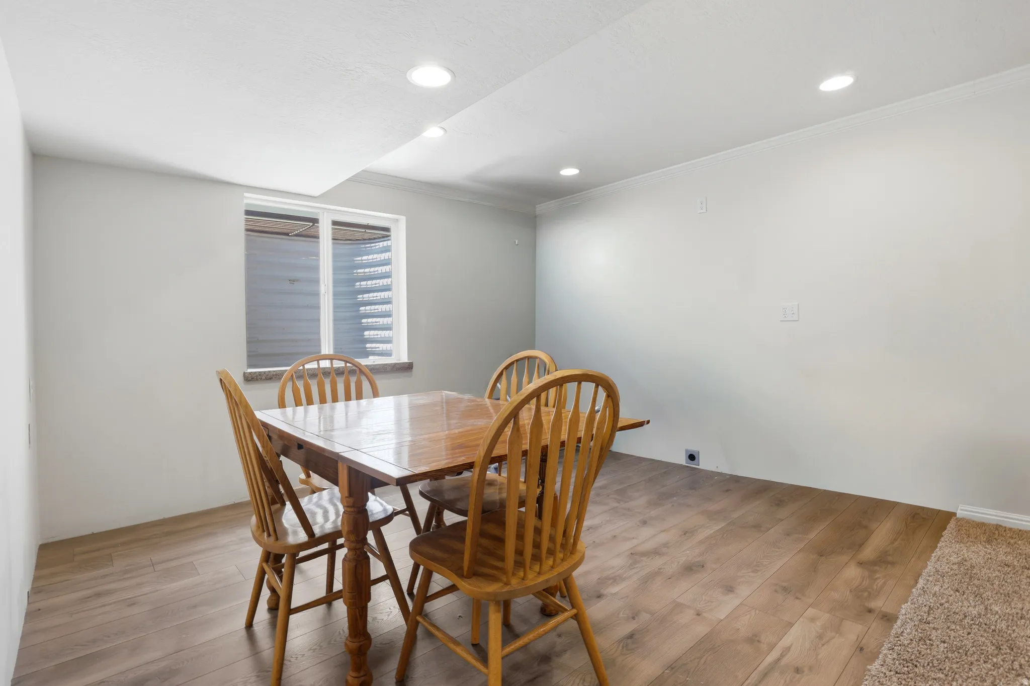 Recessed lighting illuminates this room featuring wood-finish flooring and a white ceiling