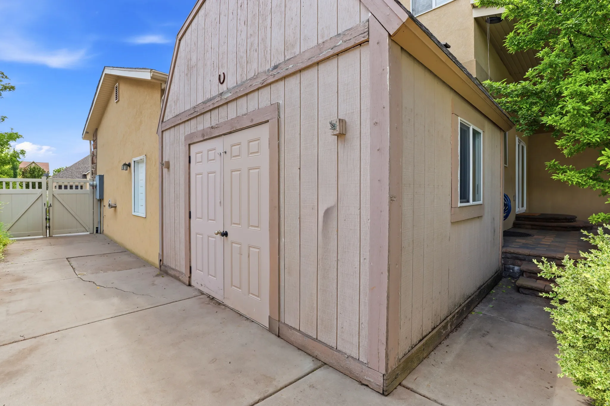 Freestanding storage shed featuring vertical siding, double entry doors, a single window, and a gabled roofline