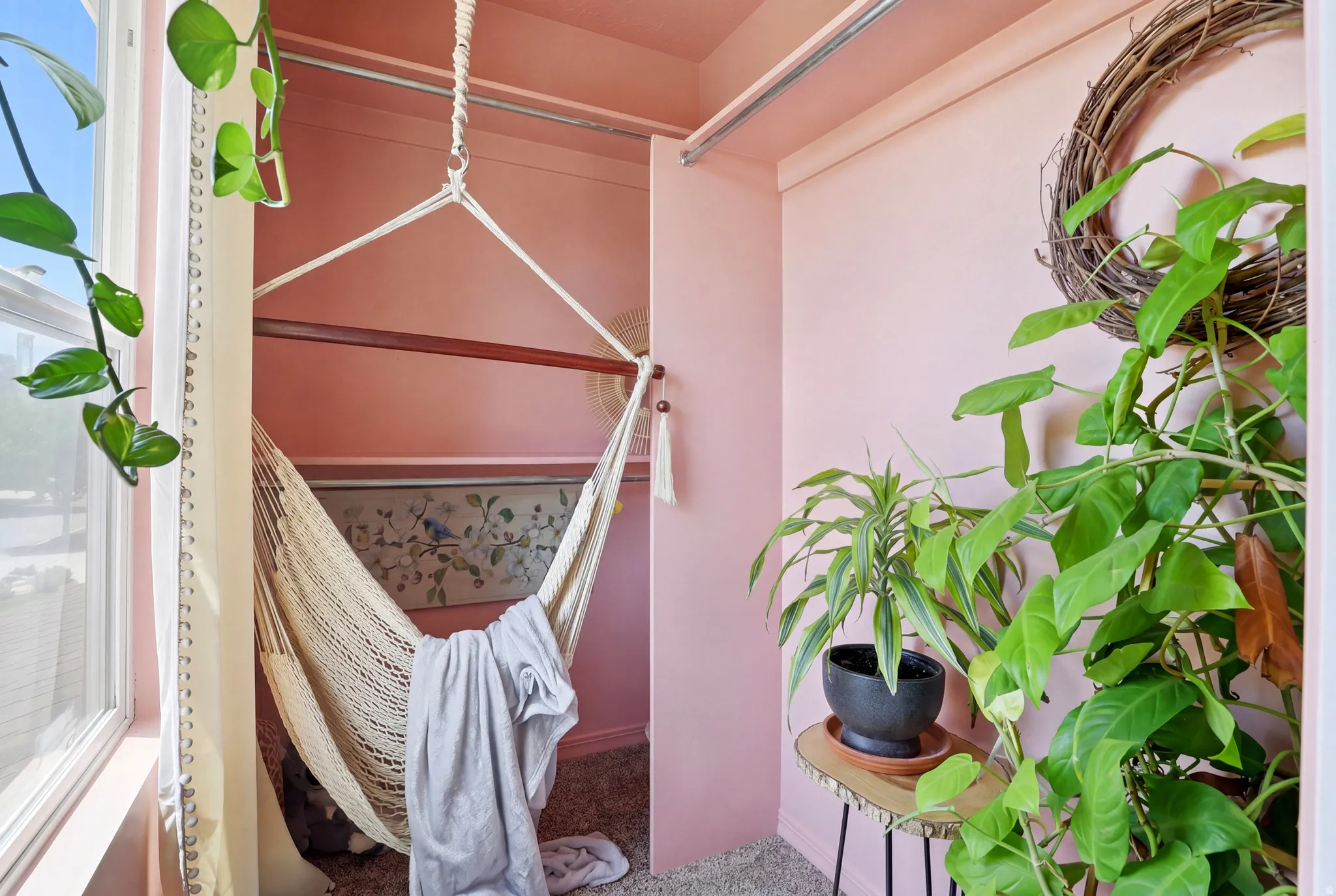 Recessed nook with soft pink walls and a textured woven hammock